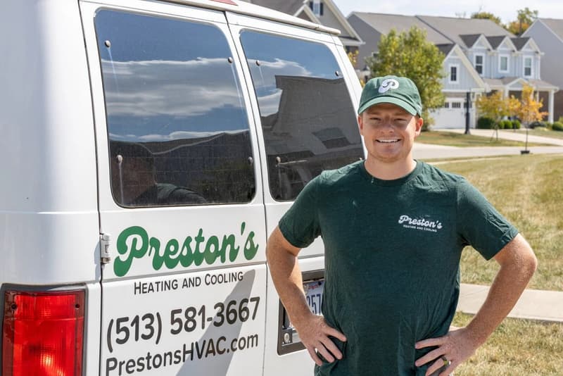 Technician smiling beside Preston's van
