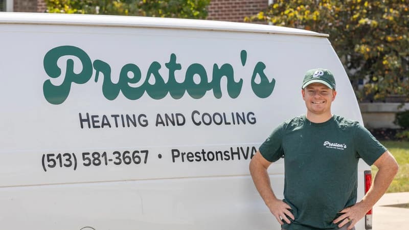 Technician standing next to Preston's Heating and Cooling van
